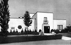 old black and white picture of flat roofed house with landscaped lawn