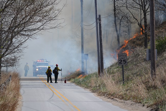 Firefighters and fire engine on the road during prescribed fire.