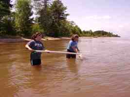 High school chemistry students collect water sample in Lake Superior.