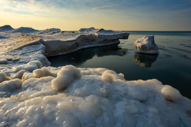 Close up of edge of smooth, gray-white shelf ice on Lake Michigan.