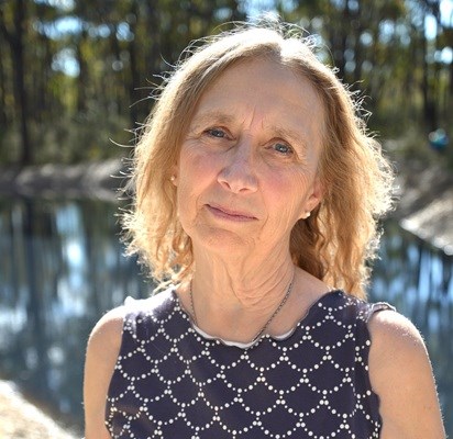 photograph of artist holding an extremely large yellow maple leaf