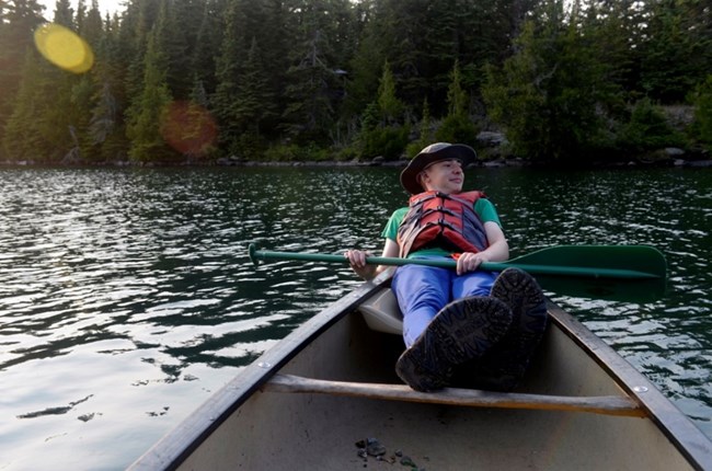 child paddling a canoe