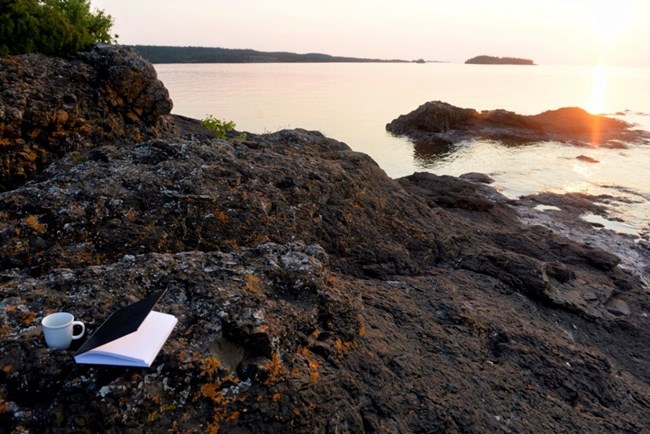sunrise, the sun lifting out of the lake and illuminating the islands and rocky shoreline