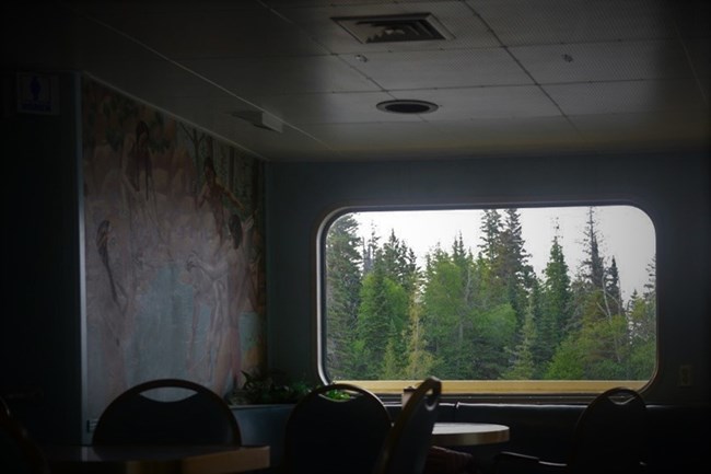Ranger III lounge in darkness with a bright image of the canal shoreline outside the window