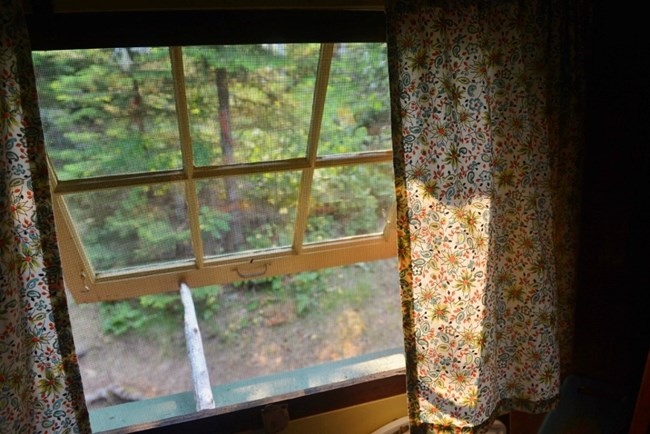 curtained window propped open with a stick