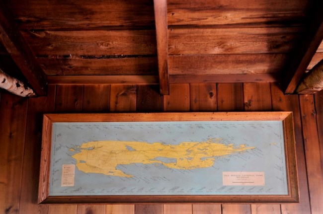 old map of Isle Royale hanging on a wood paneled wall