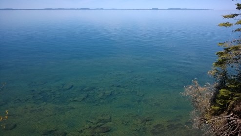 A large lake with flat water and a distant shore