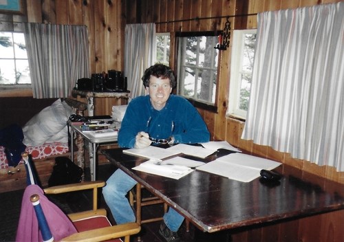 A photo shows a person sitting at a table in a cabin