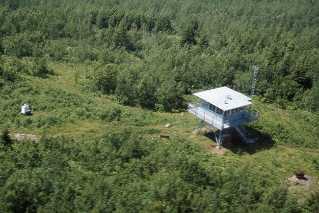lt= An aerial photo of the one story Ishpeming Fire Tower, unobstructed by foliage.