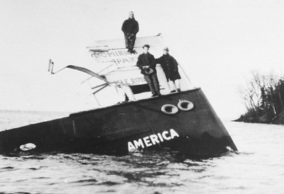 three men standing on America's bow as it slowly sank into North Gap
