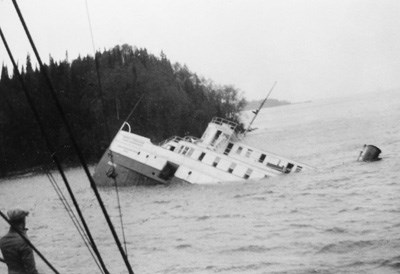 man looking on at the stern of America sinking into North Gap