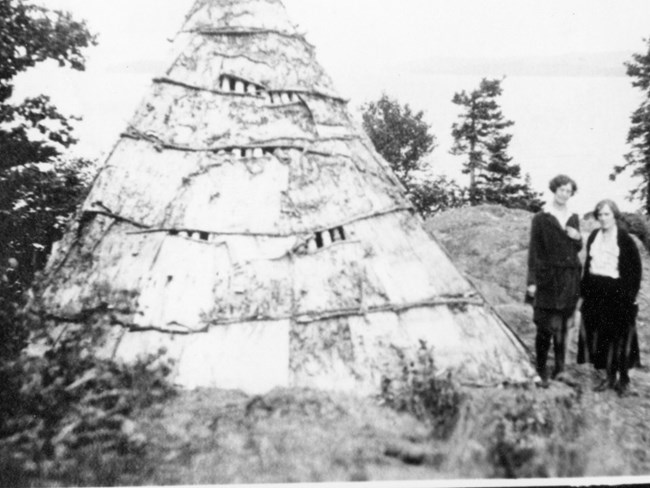 two tourists standing next to resort attraction tepee