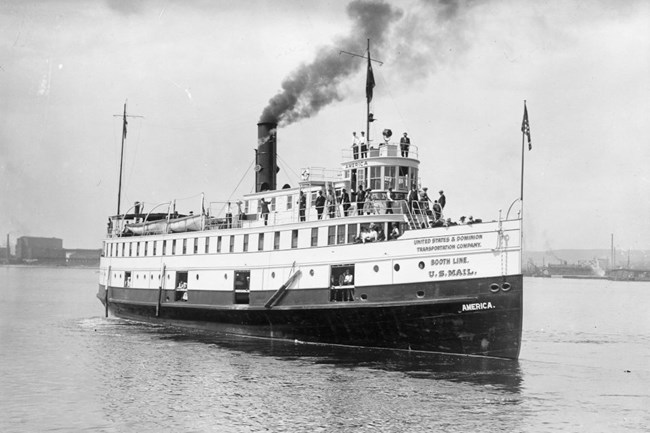 black and white photo of the SS America sailing in open water, smoke bellowing into the air