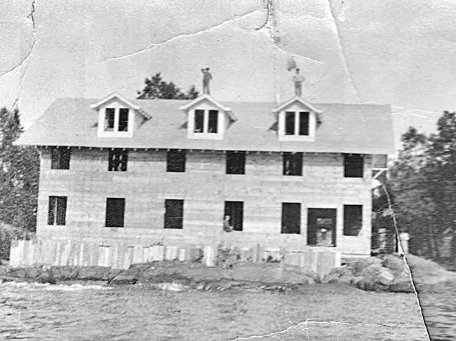 construction of two story guest building, two men standing on roof