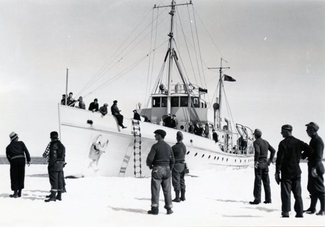 men looking onward at supply boat