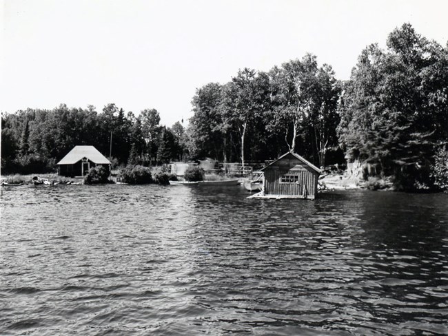 fish house with net drying racks behind it, cabin on the left
