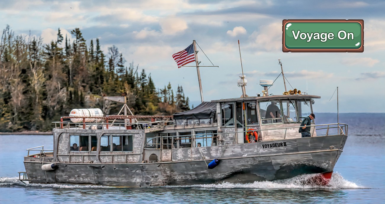 A large silver ferry sails on a big lake.