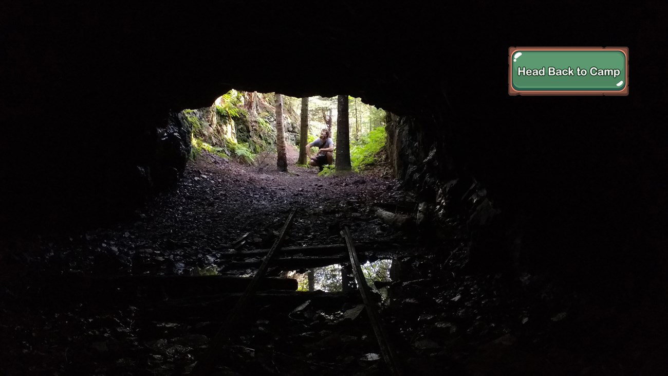 A person peers into a dark mine.