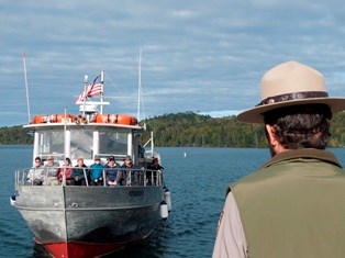 A ranger greets visitors arriving on the Voyageur II ferry.