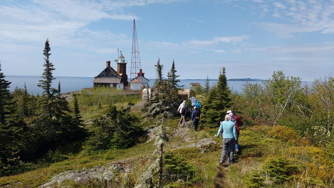 Visitors walk towards the end of an island with water surrounding it