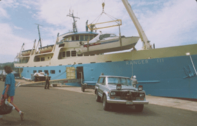 Ranger III ferry loading private boat onto bow deck with crane.
