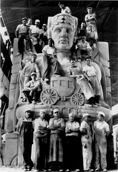 the men who carved the Egyptian pharoah on the statue are posing around it