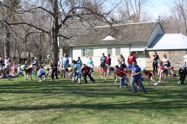 Kids on lawn of Garfield home rolling wooden eggs with spoons Kids on lawn of Garfield home rolling wooden eggs with spoons