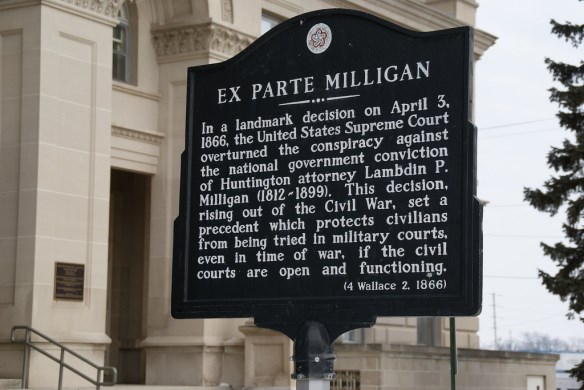 a black historical sign with gold letters