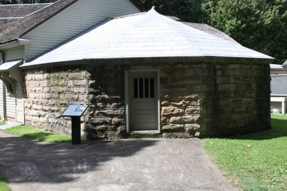 a structure that is made of stone and a window that has bars over it so you can look inside