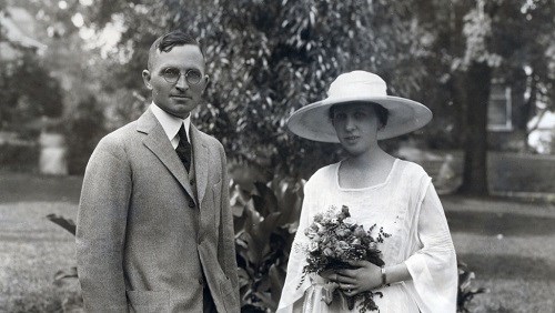 a man and woman standing next to each other in white outfits