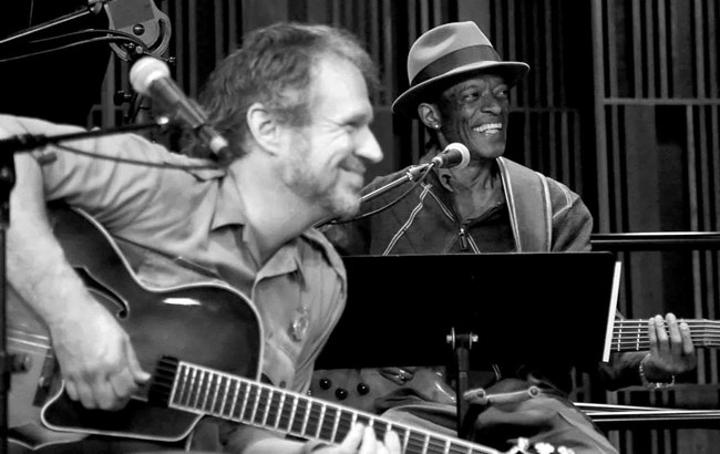 Ranger Matt smiling playing guitar and Mike Harris