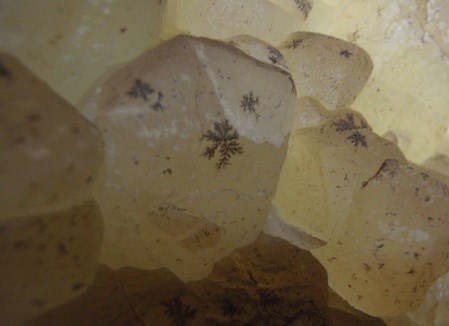 Opaque crystals with black spots.