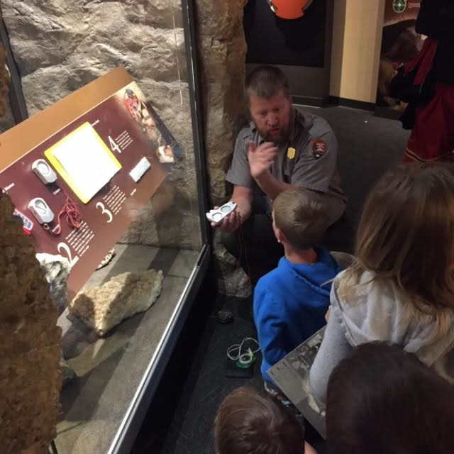 Junior Ranger in exhibits learning about caving with a Park Ranger.