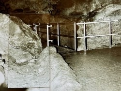 Image showing a cave room with updated concrete paths, layered over a blurred version of a similar image.