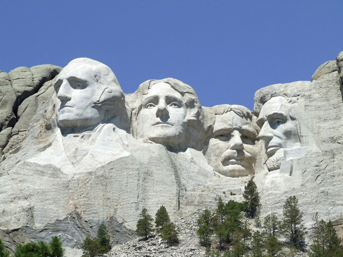 A view of Mount Rushmore under a bright blue sky.