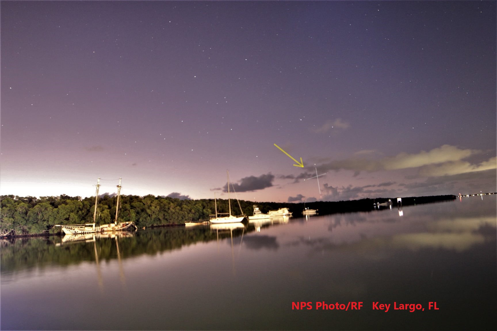 Boats at a dock, with the light of dawn just appearing in the sky.  A few stars can be seen.