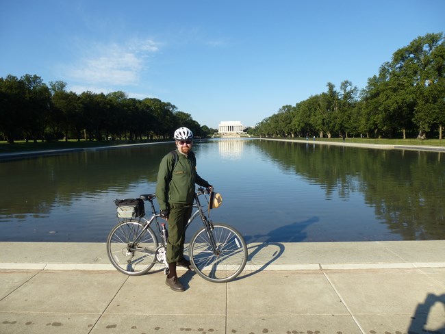 ranger on a bike in front of the rellecting pool in front of the Lincoln Memorial