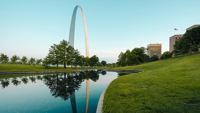 the Gateway Arch reflecting in one of the two ponds on the park grounds