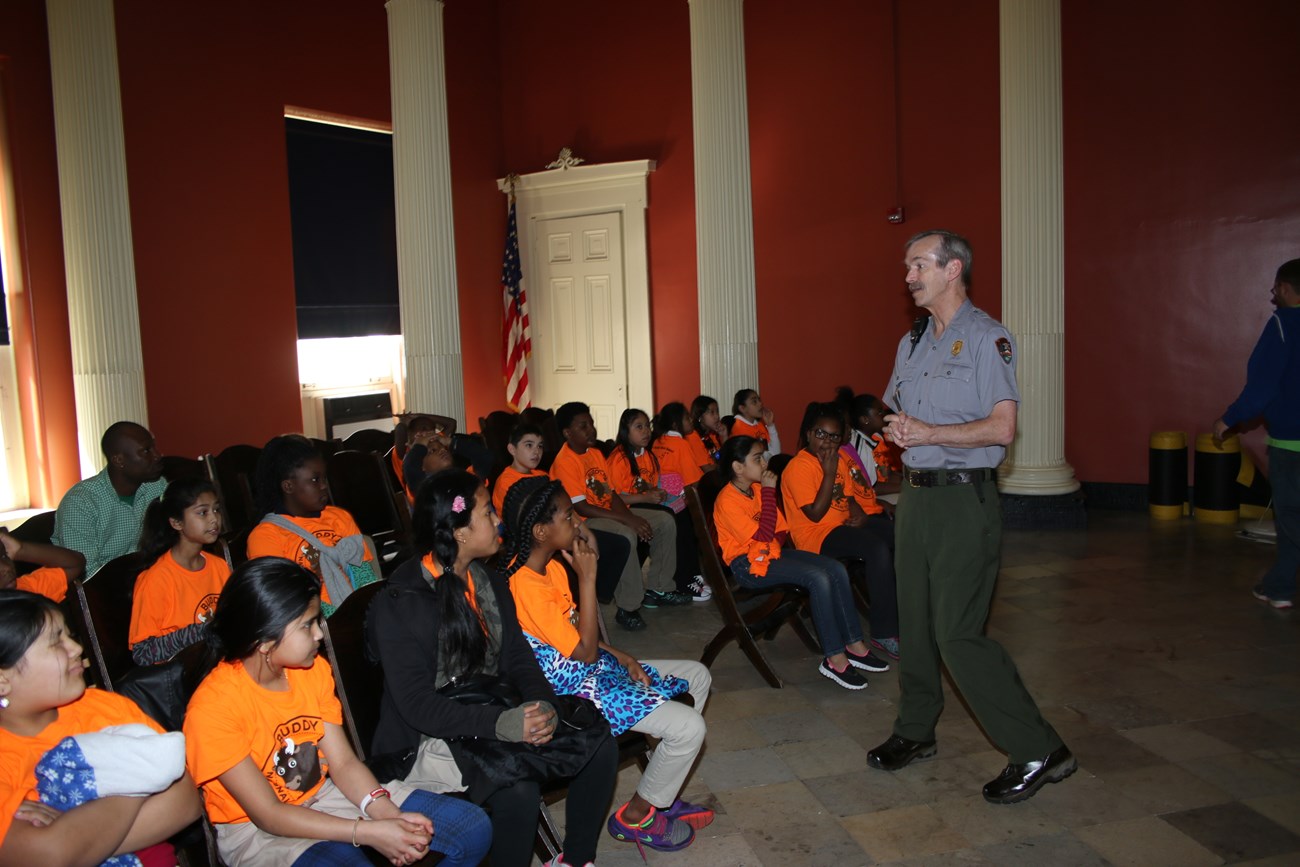 Park Ranger presenting to students inside a courthouse.