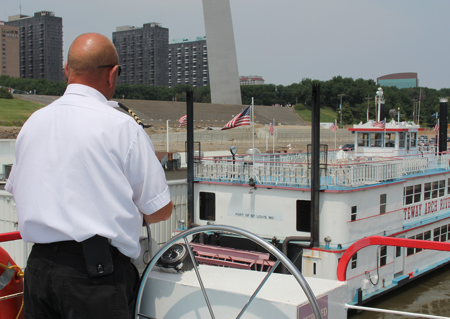 Riverboat pulls in next to another with the Arch in the background