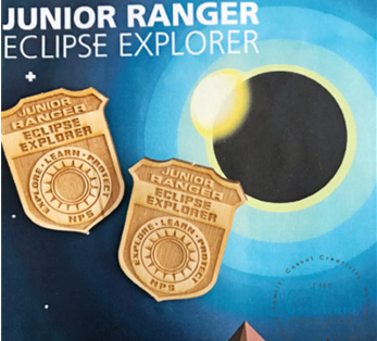 Wooden eclipse badges with a colorful background