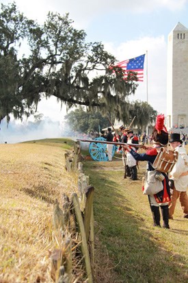 Living history reeanactors fire muskets from behind a reconstructed rampart Living history reeanactors fire muskets from behind a reconstructed rampart