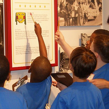 Boys on a school field trip view an exhibit about Mardi Gras Boys on a school field trip view an exhibit about Mardi Gras