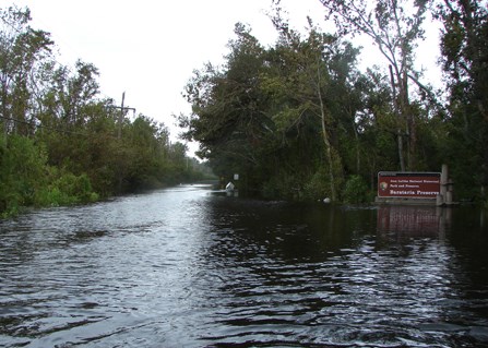 Image of Barataria Preserve entrance after hurricane with floodwaters covering road