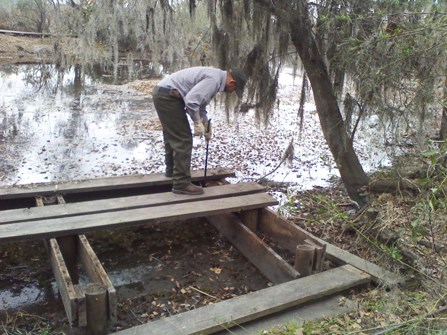 Image of man working on a wooden platform that will become a canoe dock Image of man working on a wooden platform that will become a canoe dock
