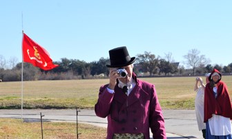 Image of man in 1815 civilian clothes taking a picture with a modern camera