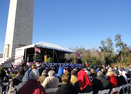 Image of people in chairs looking at stage decorated with flags and bunting Image of people in chairs looking at stage decorated with flags and bunting