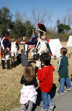 A man dressed as an 1815 soldier talks with children A man dressed as an 1815 soldier talks with children