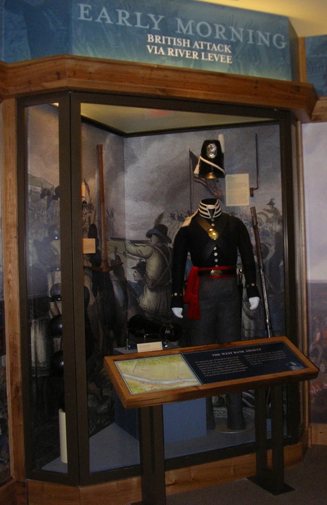 Glass exhibit case with 1815 American uniform and cannonballs