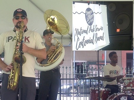 A drummer, a saxophone player, and a sousaphone player are performing, wearing "Find Your Park" shirts.